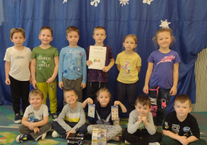 Dzieci z grupy V prezentują dyplom z Przeglądu Kolęd i nagrody - projektor ze świątecznymi obrazkami i lampion z reniferem